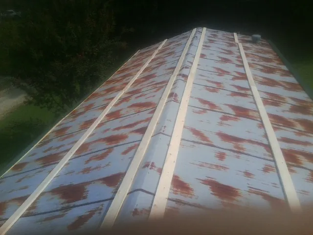 Rusted metal roof panels with new wood purlins before replacement — Storm Damage Roof Repair in West Salem by Roofing Brothers